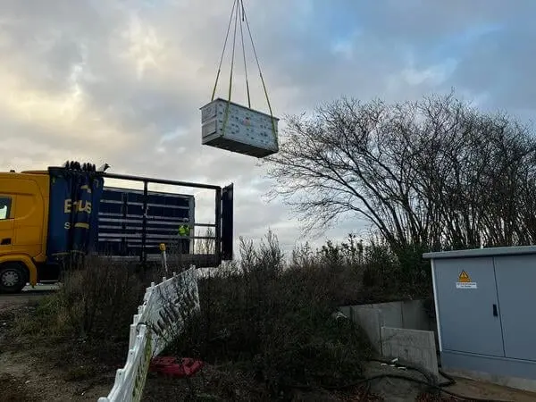 Das 400 Kilogramm schwere Lüftungsgerät hängt am Kran und wird auf die Baustelle gehoben