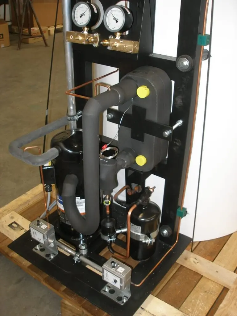 Detailansicht der Kältetechnik am Gestell: Verdichter, gedämmte Leitungen, Kupferrohre und zwei Manometer